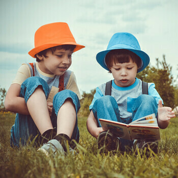 Deux enfants lisent un livre dehors - Crédits photo : Libre de droit